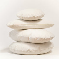 Stack of beige cushions on a light background