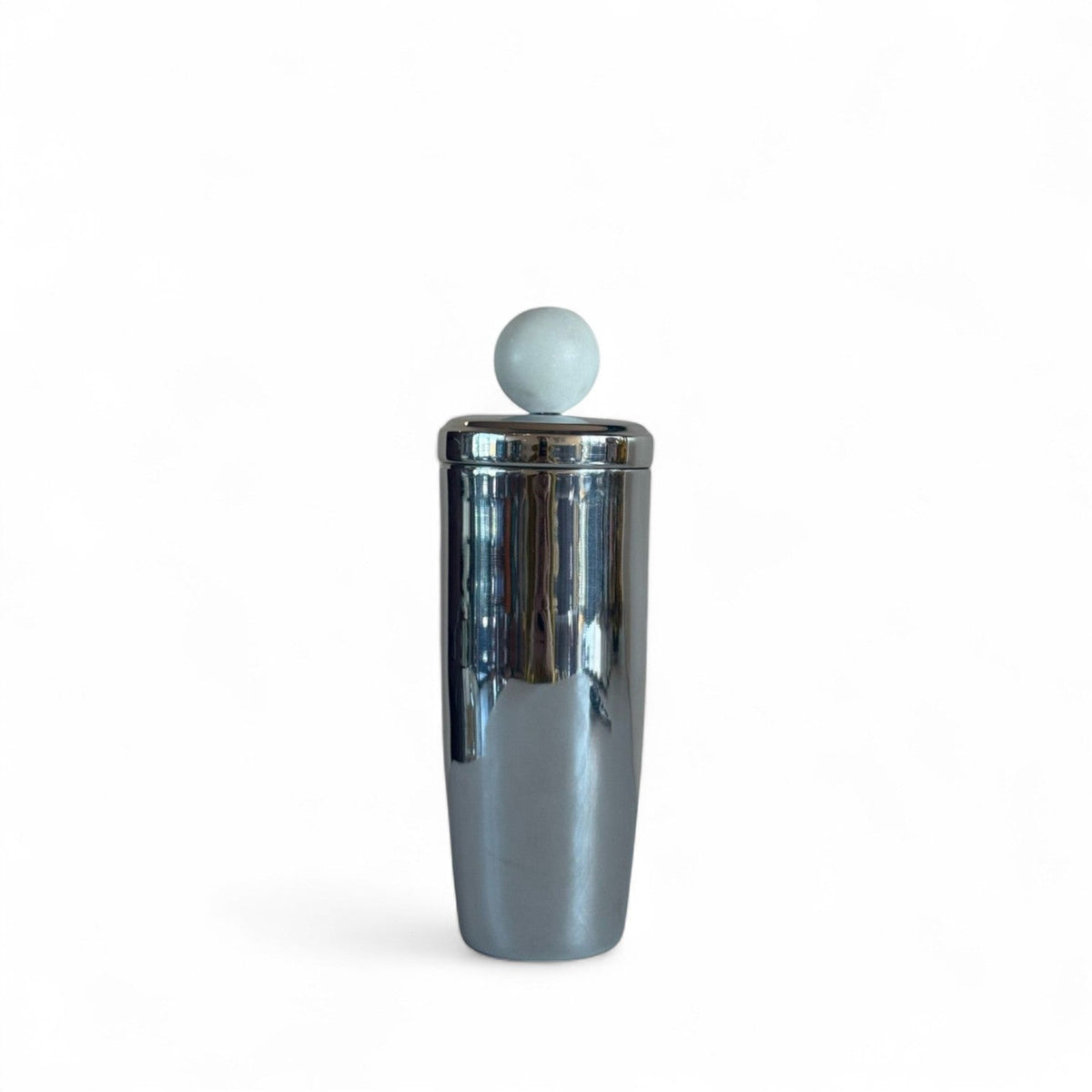 Shiny metal cocktail shaker with marble sphere on lid