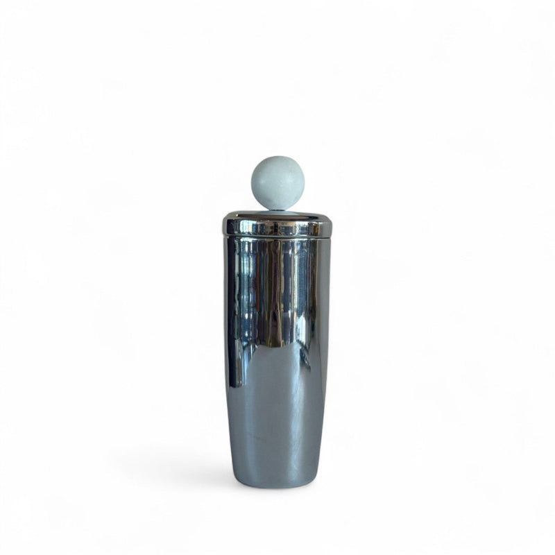 Shiny metal cocktail shaker with marble sphere on lid