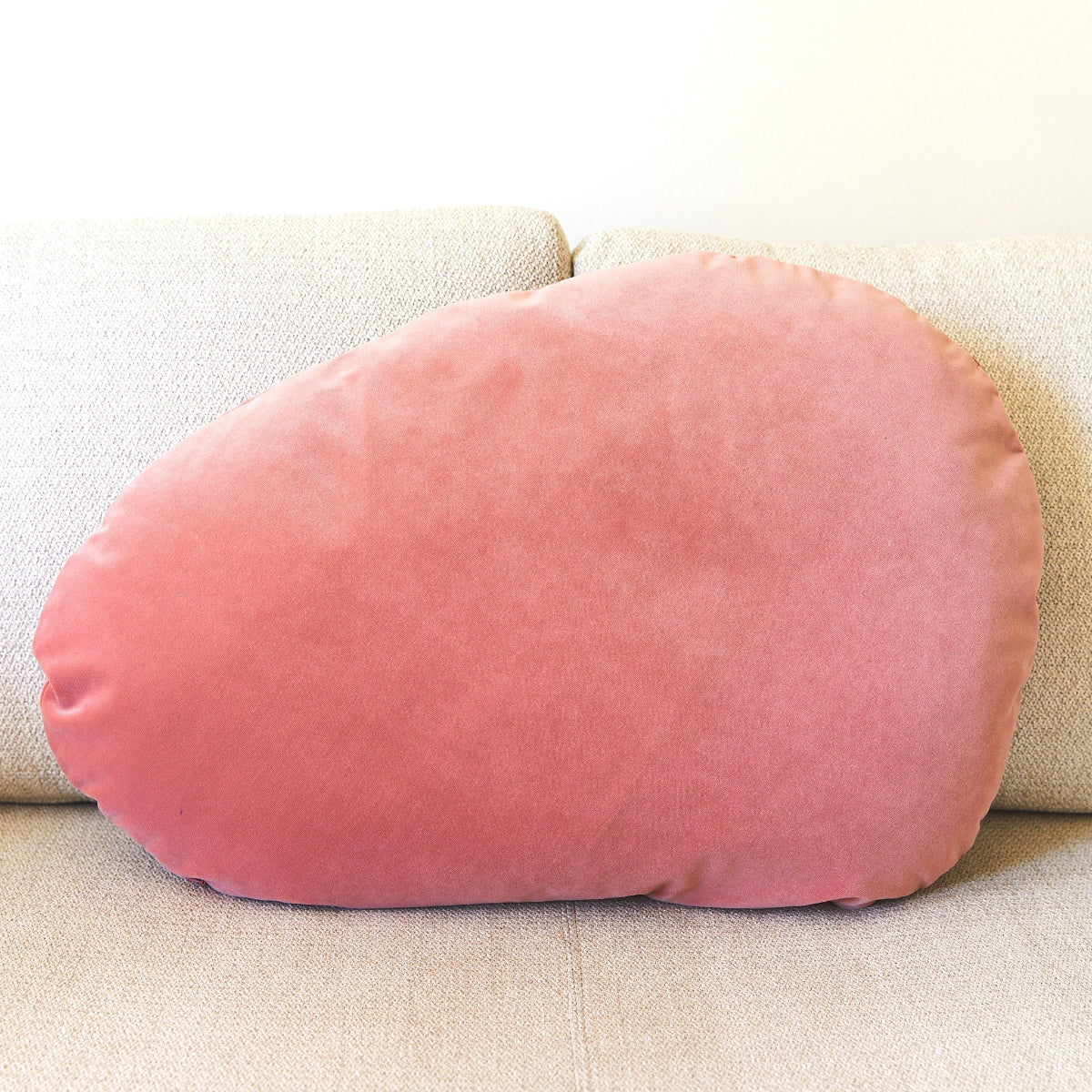 Pink velvet pillow on a beige couch
