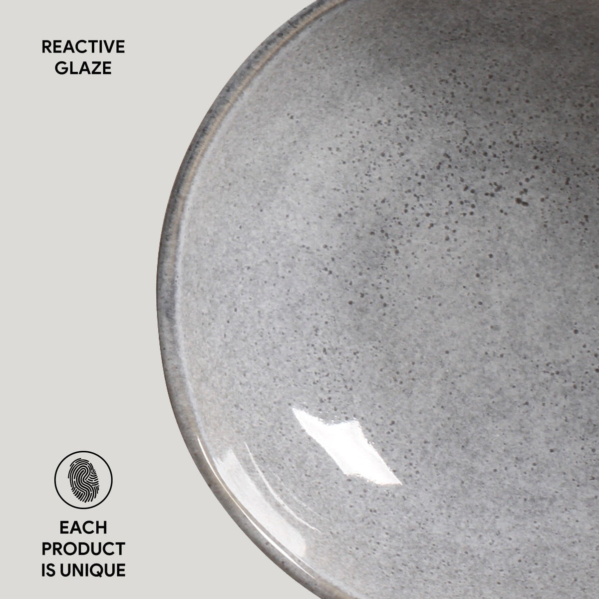 Gray ceramic bowl with reactive glaze texture on a light gray background