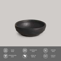 Black ceramic bowl on a gray background with safety and feature icons below.