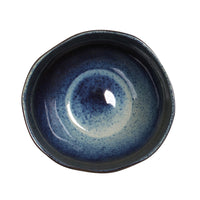 Ceramic bowl with blue speckled glaze on a white background