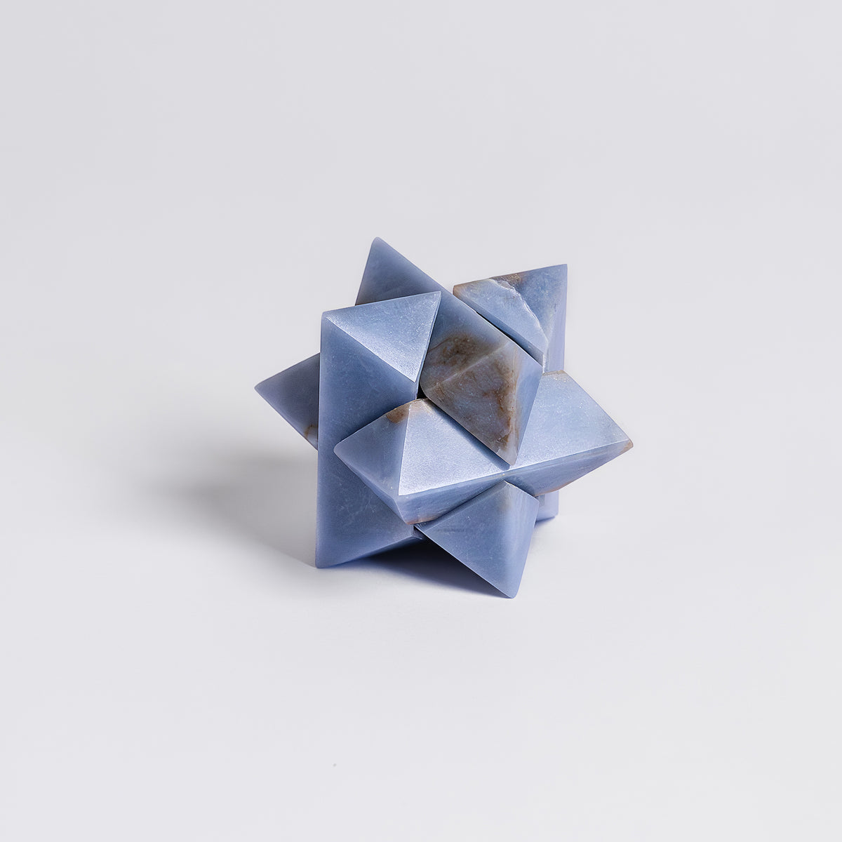 Geometric stone sculpture on a light gray background