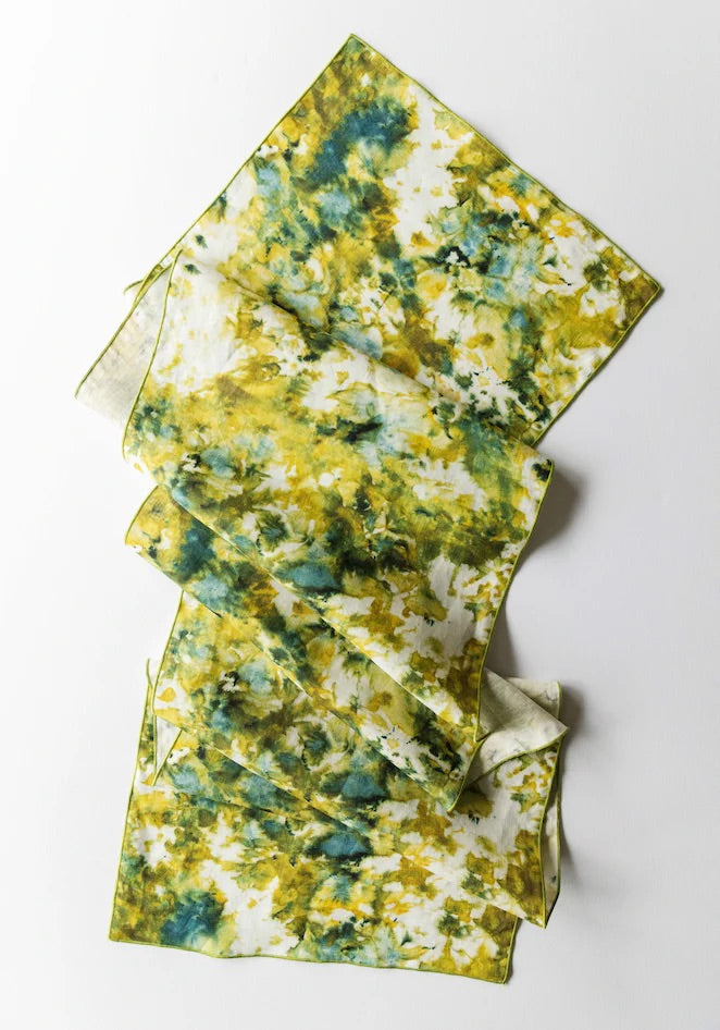 Green and gold table runner with green trim on a white background