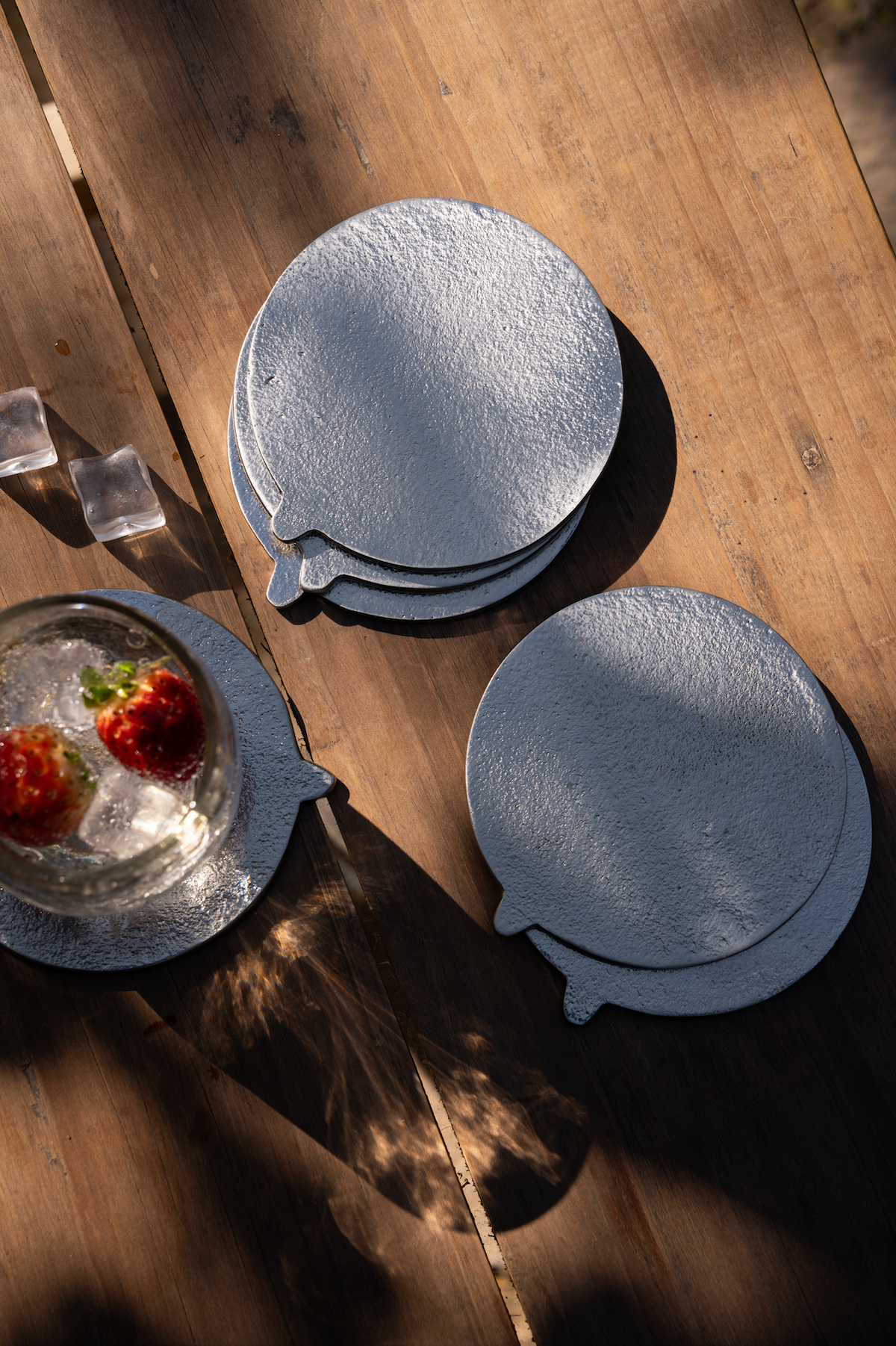 Set of round silver coasters on a wooden surface