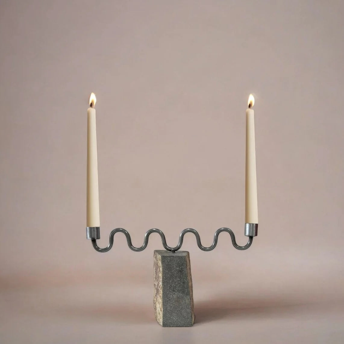 Candle holder with two candles on a neutral background