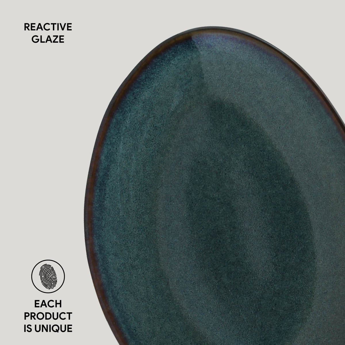 Dark teal ceramic plate with reactive glaze on a light gray background