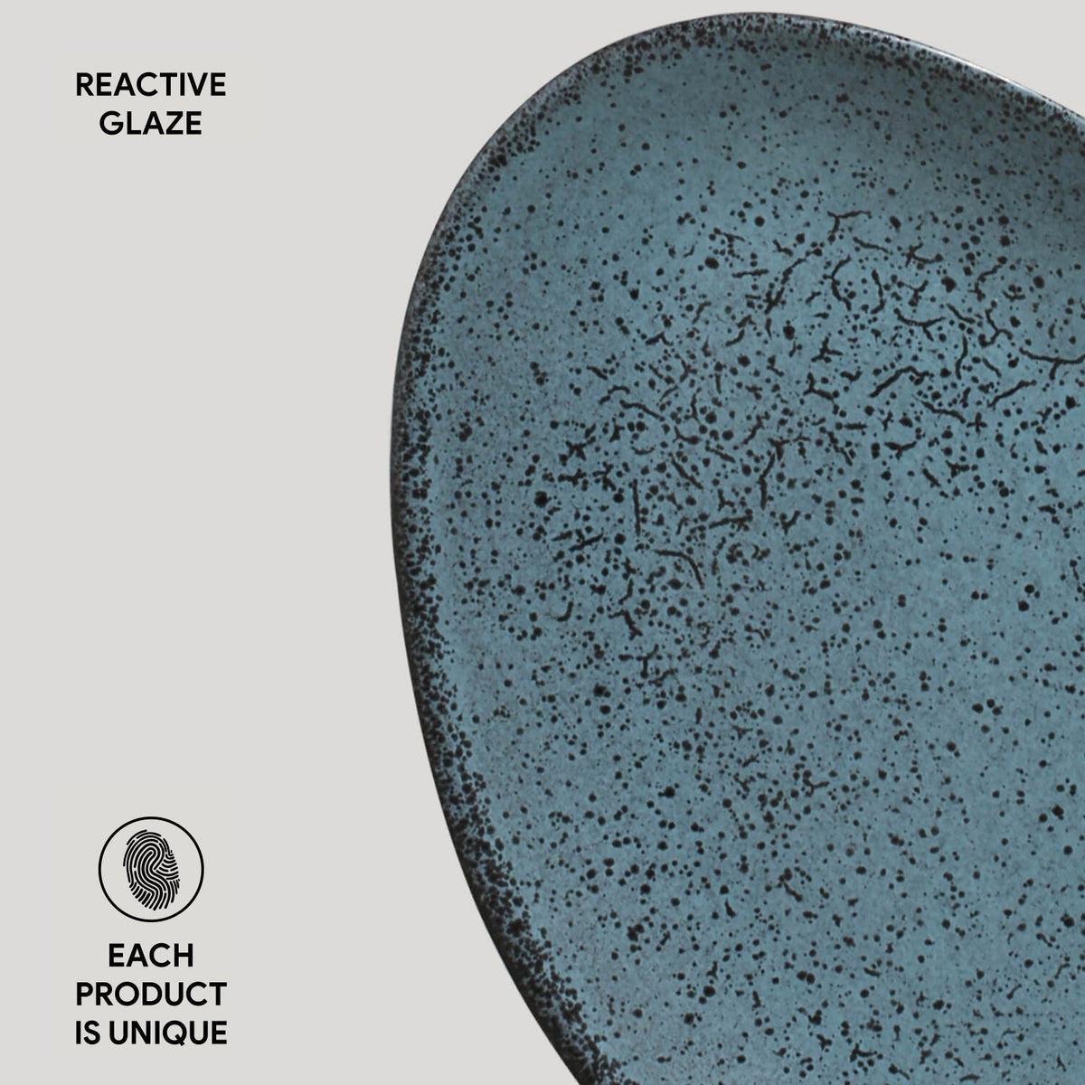 Blue ceramic plate with speckled glaze on a light gray background