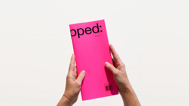 Person holding a pink magazine titled 'Untapped' on a white background