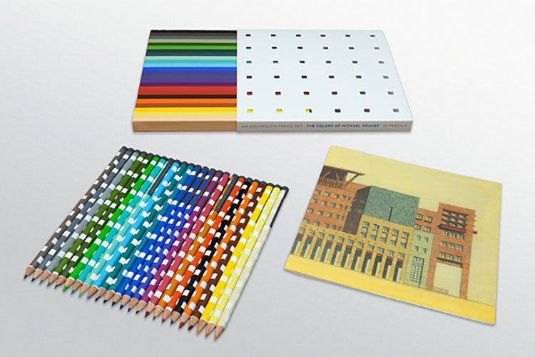 Set of colored pencils and a small booklet on a light gray background