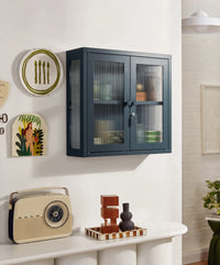 Wall-mounted cabinet with decorative items on a shelf in a room.