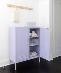 Purple storage cabinet with open doors in a room with a white wall and dark wooden floor.
