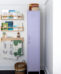 Purple locker with wooden shelves and decorative items against a white wall.