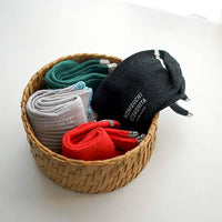 Four pairs of colorful socks rolled in a basket