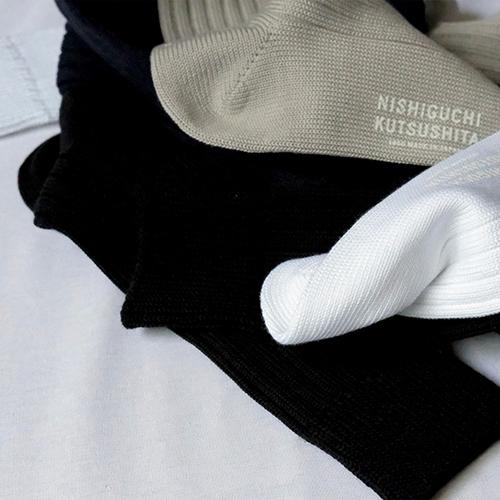 black white and beige cotton socks in a pile