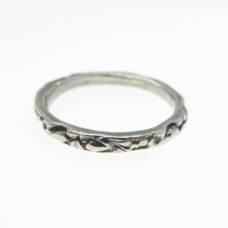 Silver ring with textured design on a white background