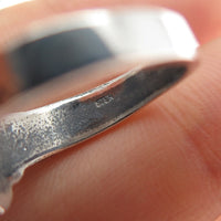 Close-up of a silver ring with a STERling stamp on the inside