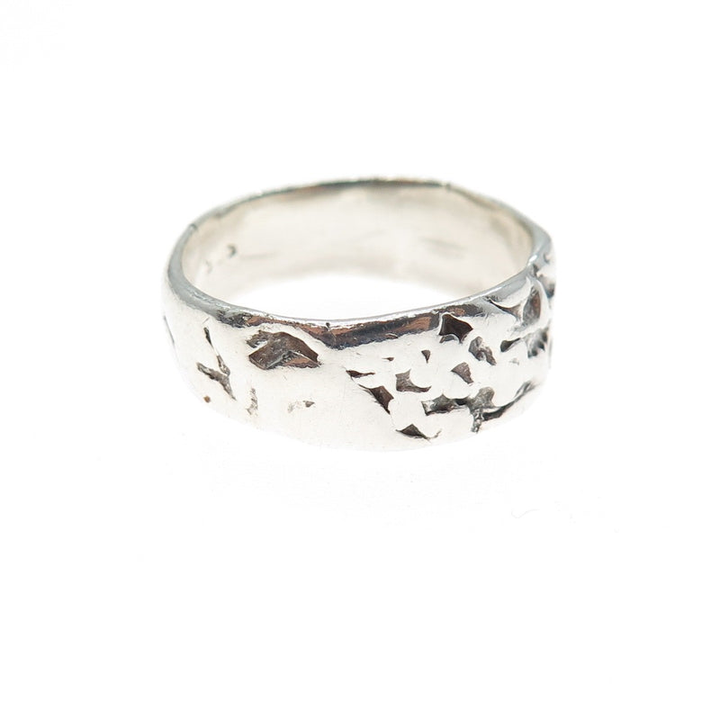 Silver ring with textured design on a white background