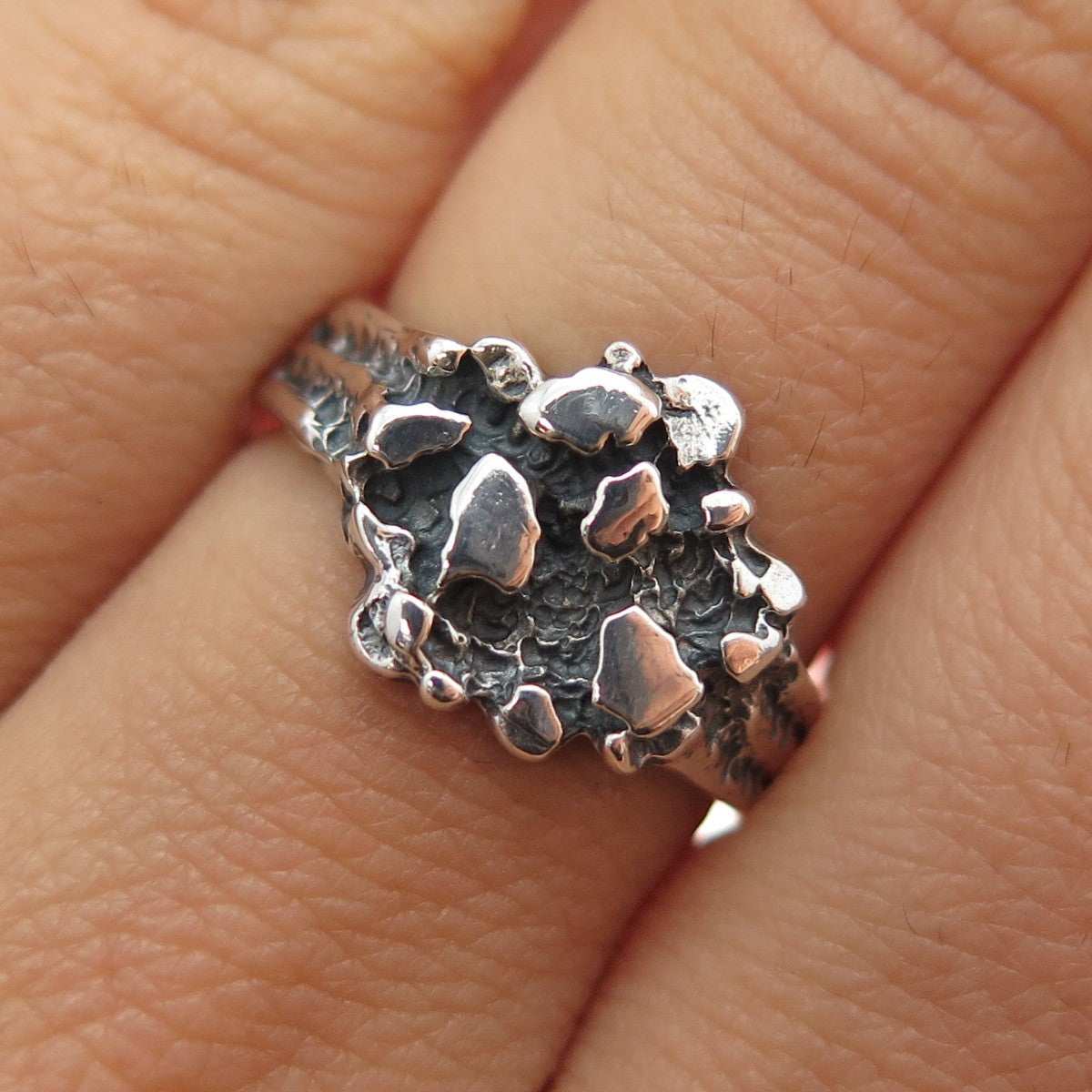 Close up on a textured silver ring on a finger