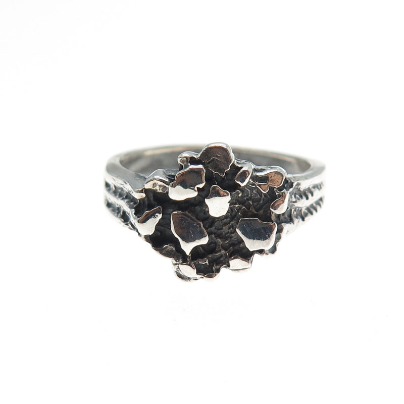 Silver ring with a textured design on a white background