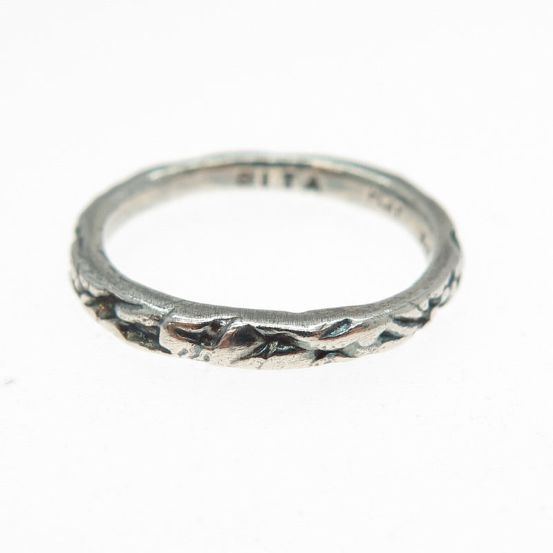 Silver ring with a textured design on a white background