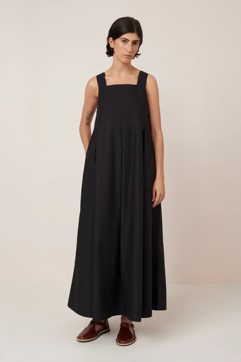 Woman wearing a black dress against a plain background