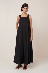 Woman wearing a black dress against a plain background