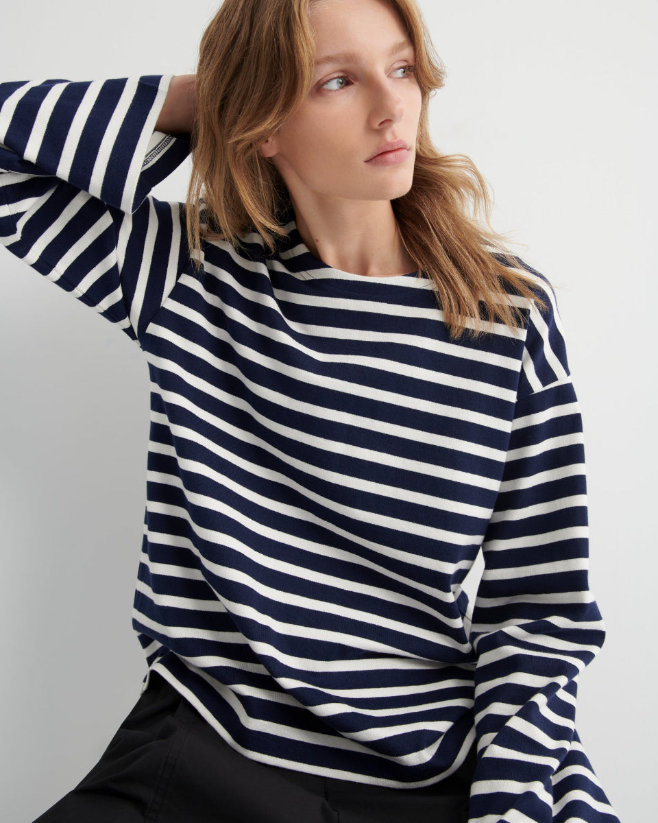 Woman wearing a navy and white striped top against a plain background