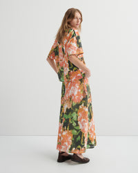 Woman wearing a floral tee with a matching skirt on a white background