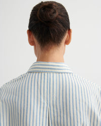 Person wearing a striped shirt with a plain background