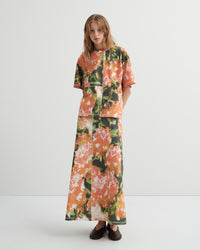 Woman wearing a floral tee and skirt on a white background