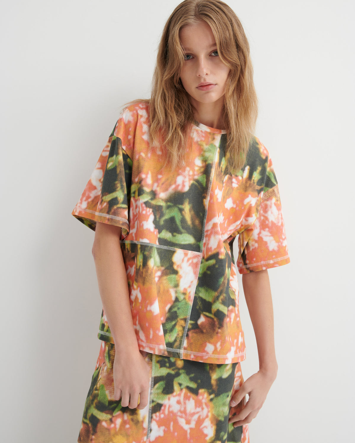 Person wearing a colorful floral print outfit against a white background