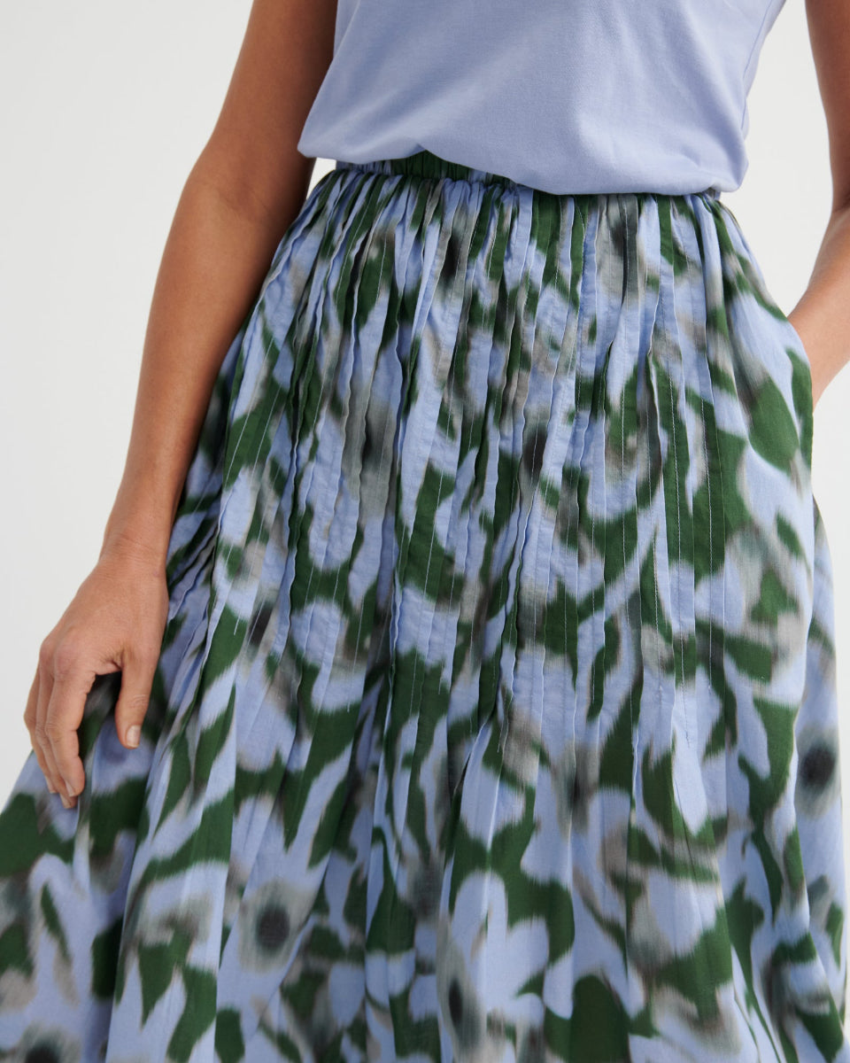 Person wearing a floral skirt with a plain background