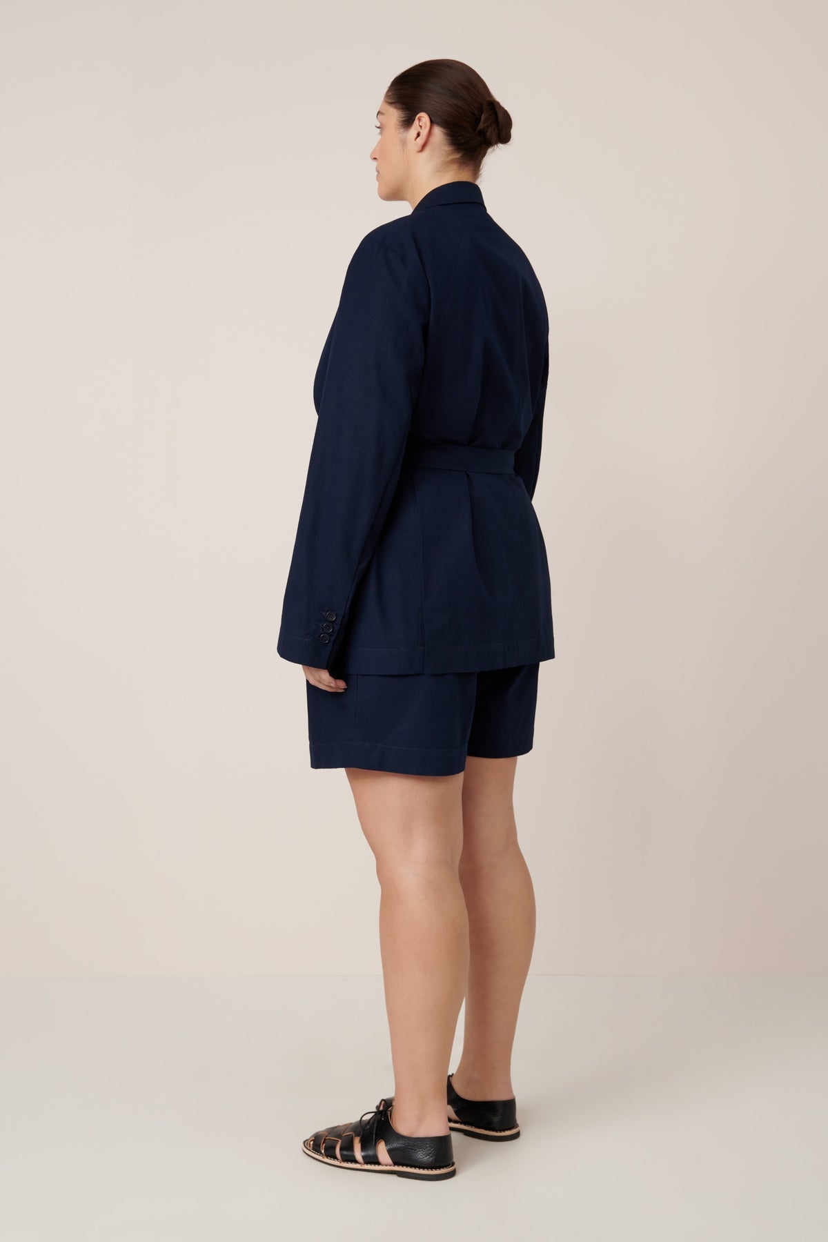 Person wearing a navy blue suit on a plain background