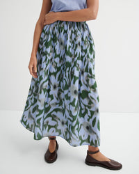 Person wearing a floral skirt on a white background