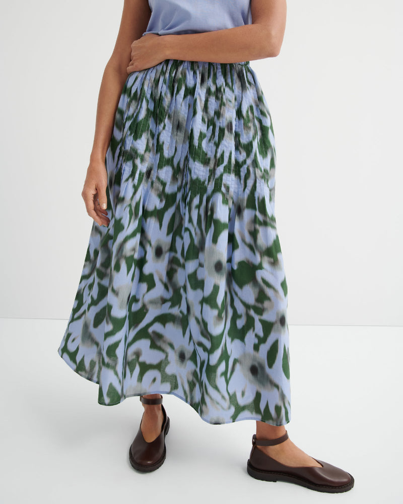 Person wearing a floral skirt on a white background