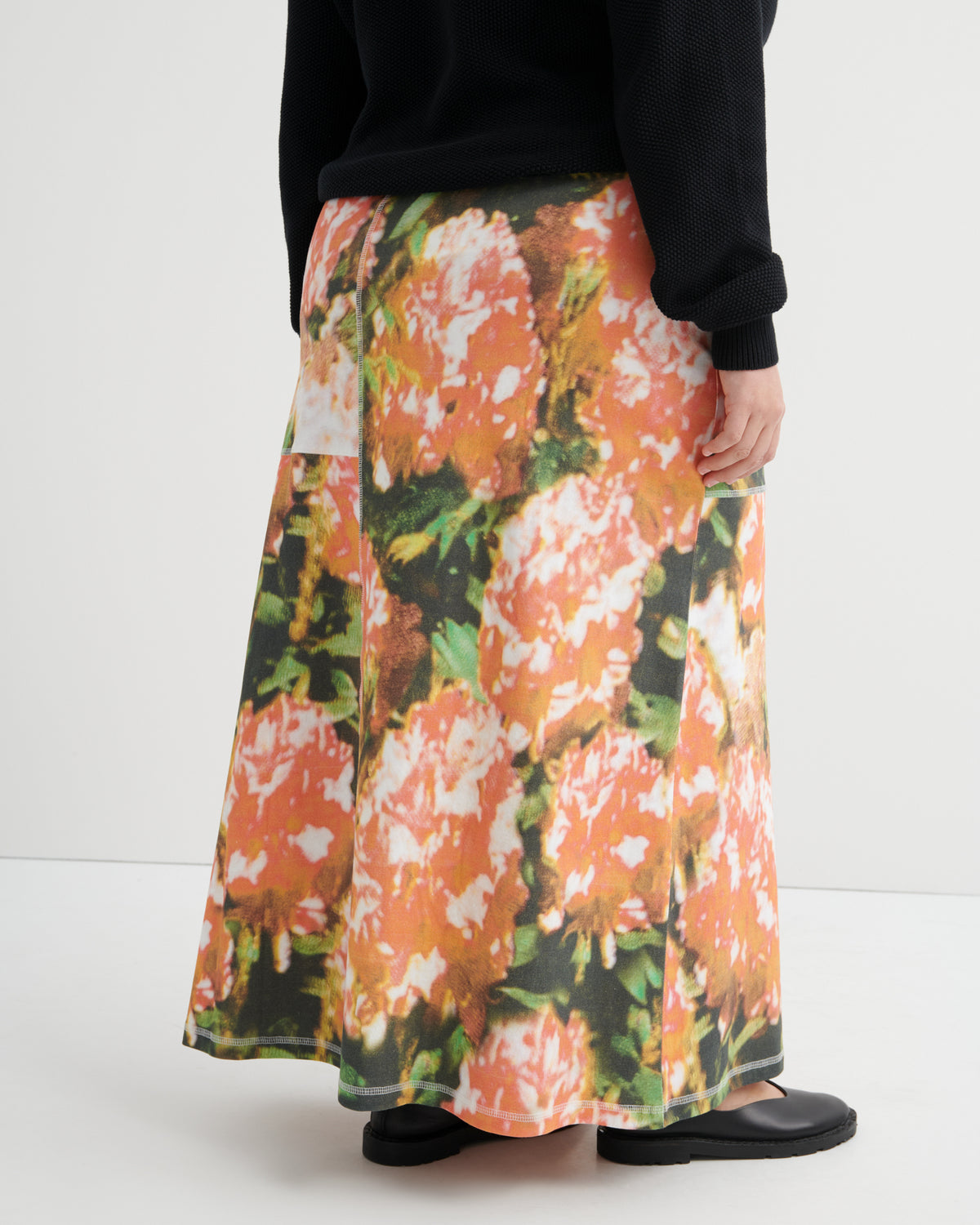 Person wearing a floral skirt with a white background
