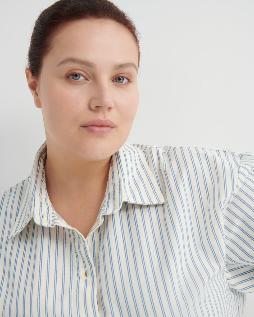 Woman wearing a striped shirt against a plain background