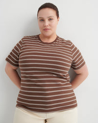 Person wearing a brown and white striped shirt against a plain background