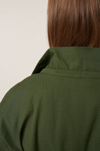 Green jacket worn by a person with a neutral background
